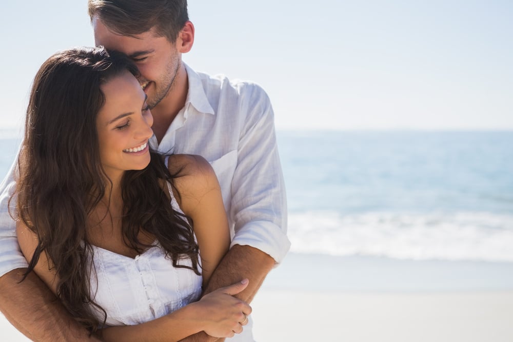 Attractive couple cuddling at the beach